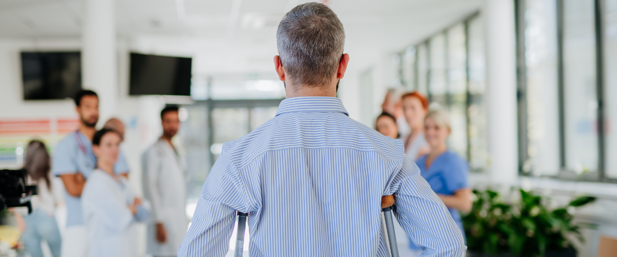 Doctor using crutches and looking at staff