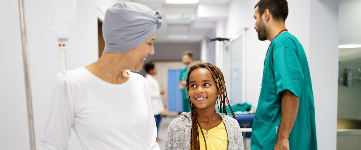 Mom with Cancer cheerfully walking with young daughter in hospital