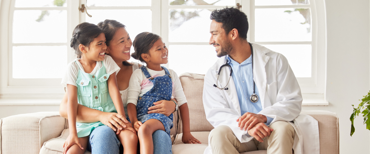 Happy doctor sitting on the couch with his wife and children